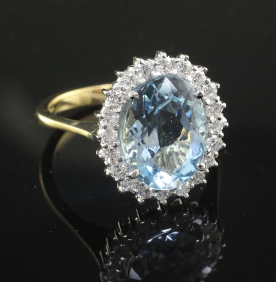 A modern 18ct gold, aquamarine and diamond oval dress ring, size O.